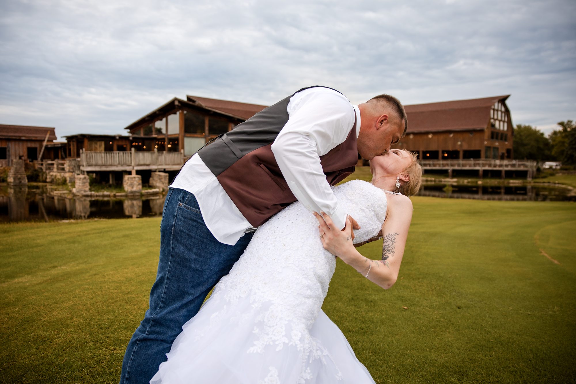 Kenneth dipping Erica for a kiss on the lawn at their wedding venue